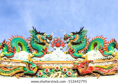 Twin dragons statue on the roof of Chinese temple with blue sky