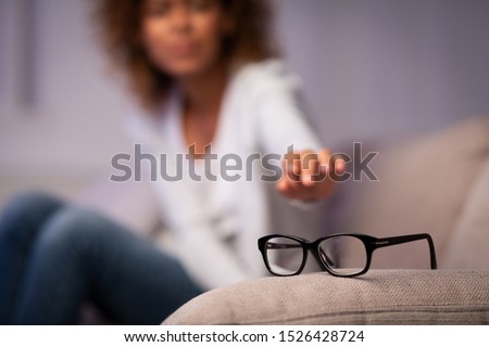 Eyesight problem. Woman reaching for eyeglasses on sofa, having poor eye sight Royalty-Free Stock Photo #1526428724