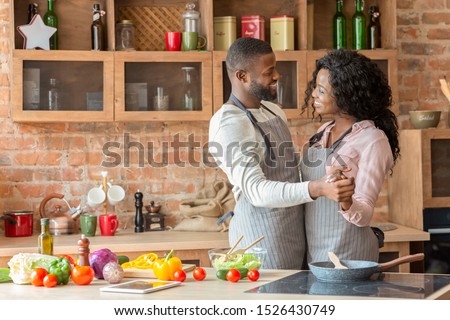 Happy moments. Romantic african american couple dancing in kitchen while cooking, copy space