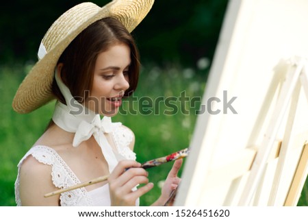 young woman draws a picture on white canvas