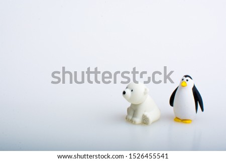 Penguin and polar bear rubber toys, cute animal shaped rubber doll isolated in white background. 