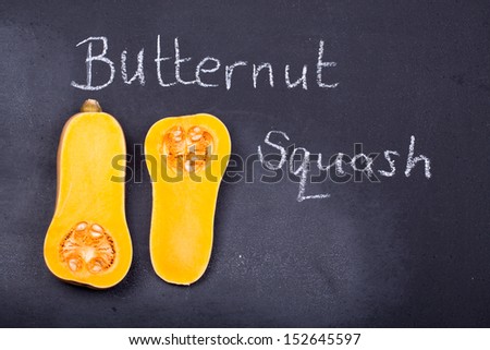 Halved butternut squash on a chalkboard background