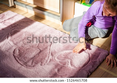 Young sad girl drawing two big hearts on the kids room carpet. Loneliness and child sadness, arguing at home, divorce in family, children seeking love and family heat social issues help concept