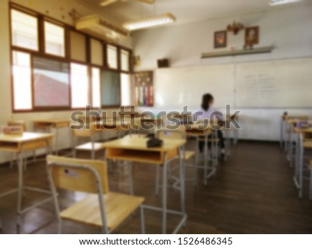 Blurred image of A female student sit alone in the exam room, she was the last person to finish the exam.