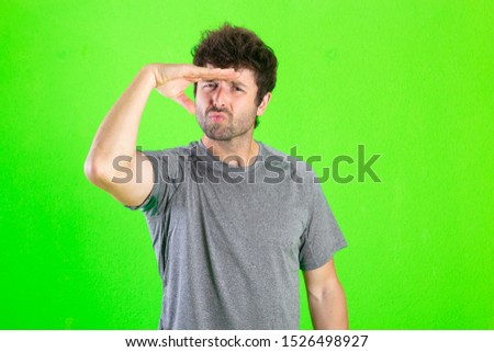 caucasian crazy man observing something too far away over green background