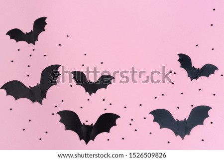 Flat lay with Black bats for halloween party. Paper decorations on pink background for holiday card or invitation. Copy space. 