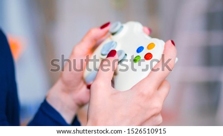 Close up shot of woman hand with joystick or gamepad at home. Gaming, hobby, technology, video game and leisure time concept