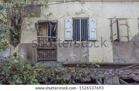 abandoned residential hut house with completely damaged window grill and air cracks on the wall