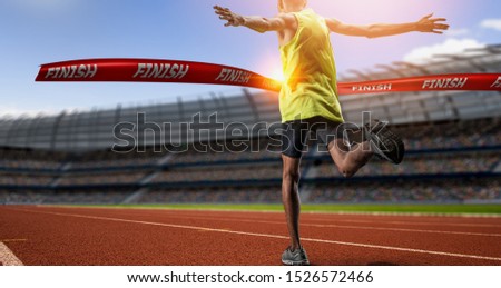 Winning young male Athlete crosses the finish line. Royalty-Free Stock Photo #1526572466