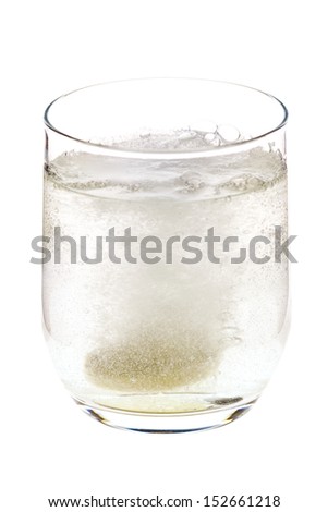 Fizzing pill tossed into the glass, dissolving and releasing bubbles, isolated on white background