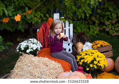 girl eating apple in autumn background
