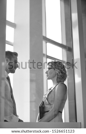 Black and white photo of an attractive man and woman working together in an empty office