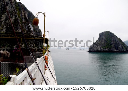 Boat deck, crusie ships and limestone cliffs in Ha Long Bay, Vietnam on a cloudy day