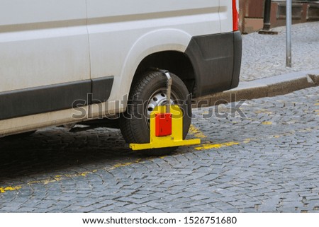 The car wheel is blocked due to a parking violation.