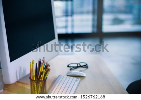 Interior Background picture of desk in office with PC computer and pencil box and keyboard and glasses