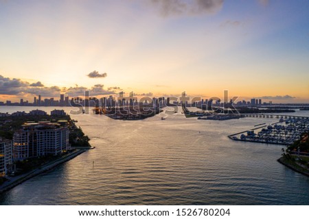 Twilight aerial Miami scene including water port and islands view of Downtown in far background