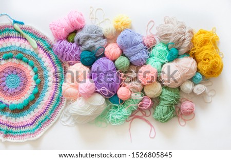 Colored yarn on a white background. Crochet hooks, scissors, and accessories.