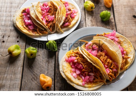Traditional mexican pork tacos  called cochinita pibil on wooden background