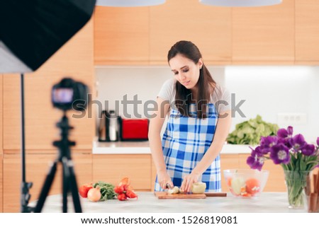 Female Food Vlogger Filming a Cooking Video in her Kitchen. Woman behind the scenes on a cooking live streaming show
