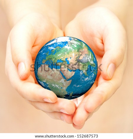 Human hand holding a globe. Elements of this image furnished by NASA.