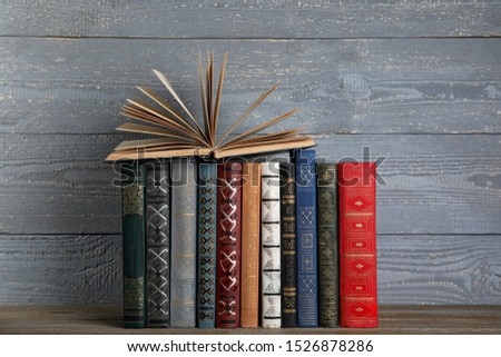Stack of hardcover books on grey wooden background