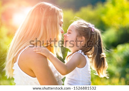 Kids love. Lifestyle portrait mom and daughter in happy mood at the outside. Happy loving family - mother and daughter