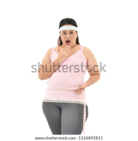 Overweight Asian woman measuring her waistline fat tummy isolated on white background