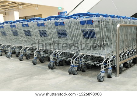 Row of shopping cart in store, Blue handles of shopping trolleys standing in the row 