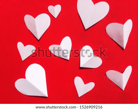White paper heart on a red background.