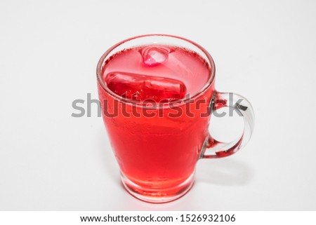 Red water in a glass on white background
