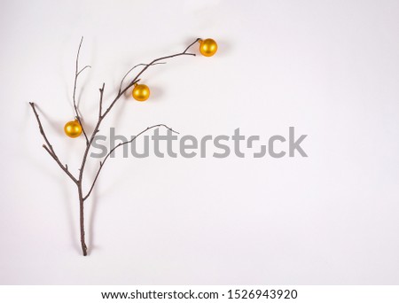Holiday greeting card. Flat lay, minimal nature christmas concept. Copy space. Branch decorated with small christmas golden balls.