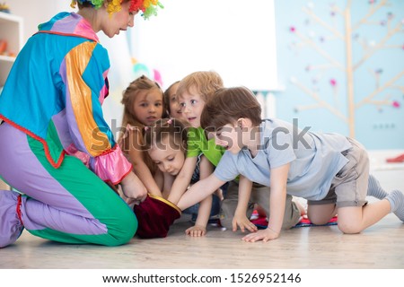 Clown entertaining preschool kids on birthday party. Games with animator