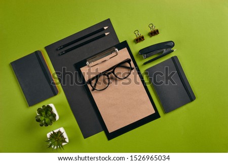 Top view in focus with different office equipment, supplies, stationery. Green background with copy space. Education, workplace concept. Close-up.