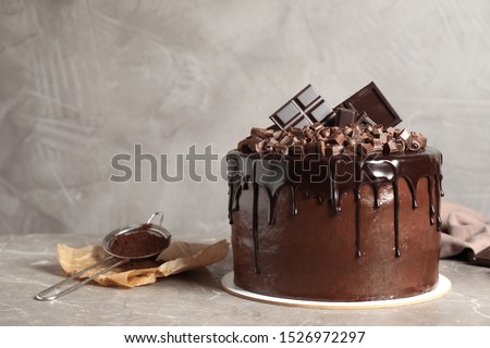 Freshly made delicious chocolate cake on marble table against grey background. Space for text