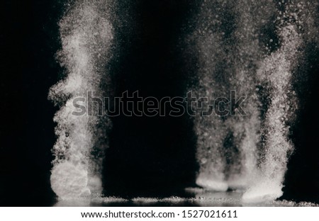 Few tablets dissolving in water with bubbles on black background