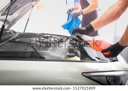 Car detailing maintenance, cleaning engine with the foam and a brush