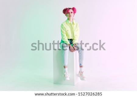 young woman with beautiful haircut looks at the camera in jeans