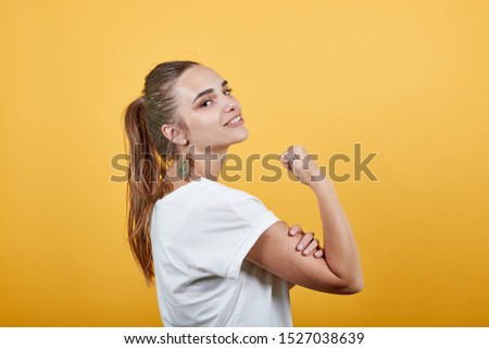 Girl touching bicep muscle also trying to show power in symbolic way