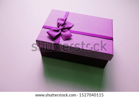 
Purple gift box placed on a colorful floor