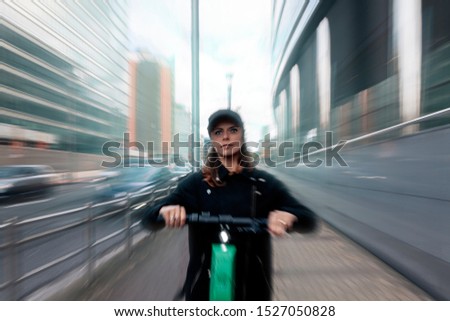 real moving picture of a woman driving an electric scooter along a reserved fast track in a busy city road