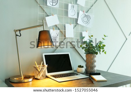 Comfortable workplace with mood board in room