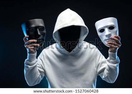 Masked man in hoodie. Dark background. Royalty-Free Stock Photo #1527060428