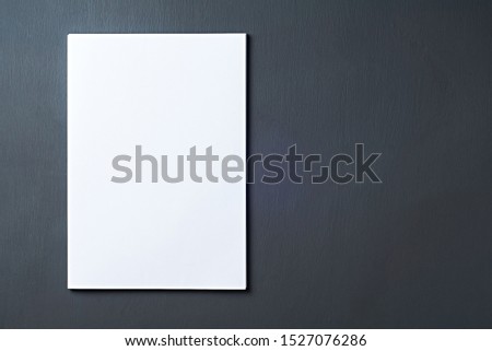 Single heap of blank white paper sheets lies on dark concrete table on workplace of secretary, director, boss or other worker of company. Space for text. Top view