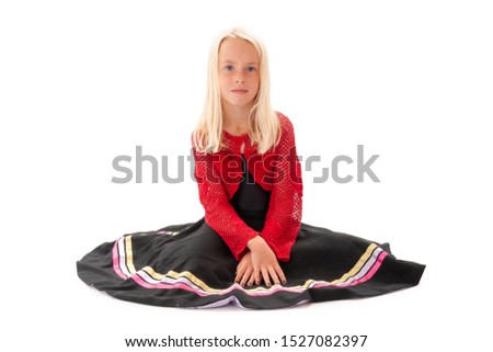 Pretty young blonde girl sat on floor in flowing skirt. Isolated on white background