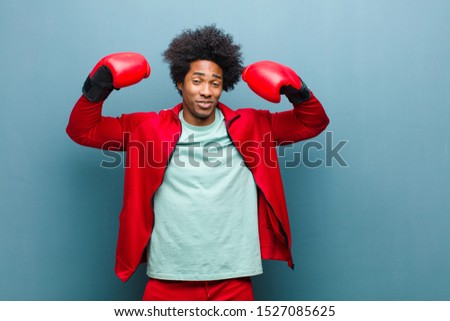 young black man with boxing gloves against blue grunge wall
