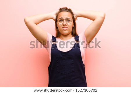 young  woman feeling frustrated and annoyed, sick and tired of failure, fed-up with dull, boring tasks against pink background