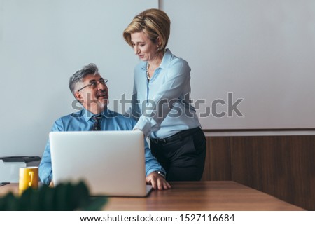businesspeople working together in office on laptop computer