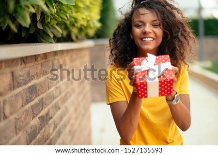 Young african woman giving a present