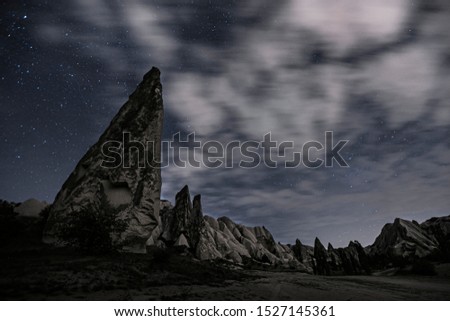 Cappadocia at night. Long exposure photo of cloudy night sky with stars and volcanic forms. 