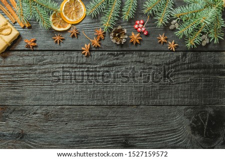 Christmas fir tree branches and pine cones on wooden dark, black textured background.  Flat lay, top view, copy space. 